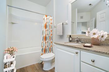 A white bathroom with a toilet, sink, and shower.